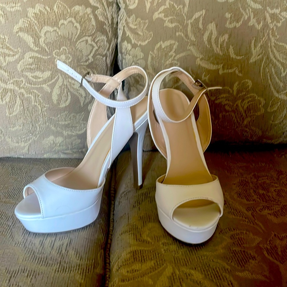 White heels with wrap around ankle strap with buckle. 4 inch heel.